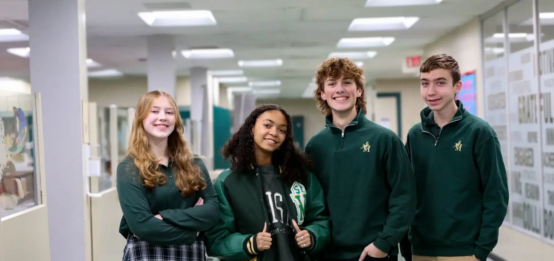 St Vincent St Mary High School students in corridor in between classes, smiling, giving thumbs up.