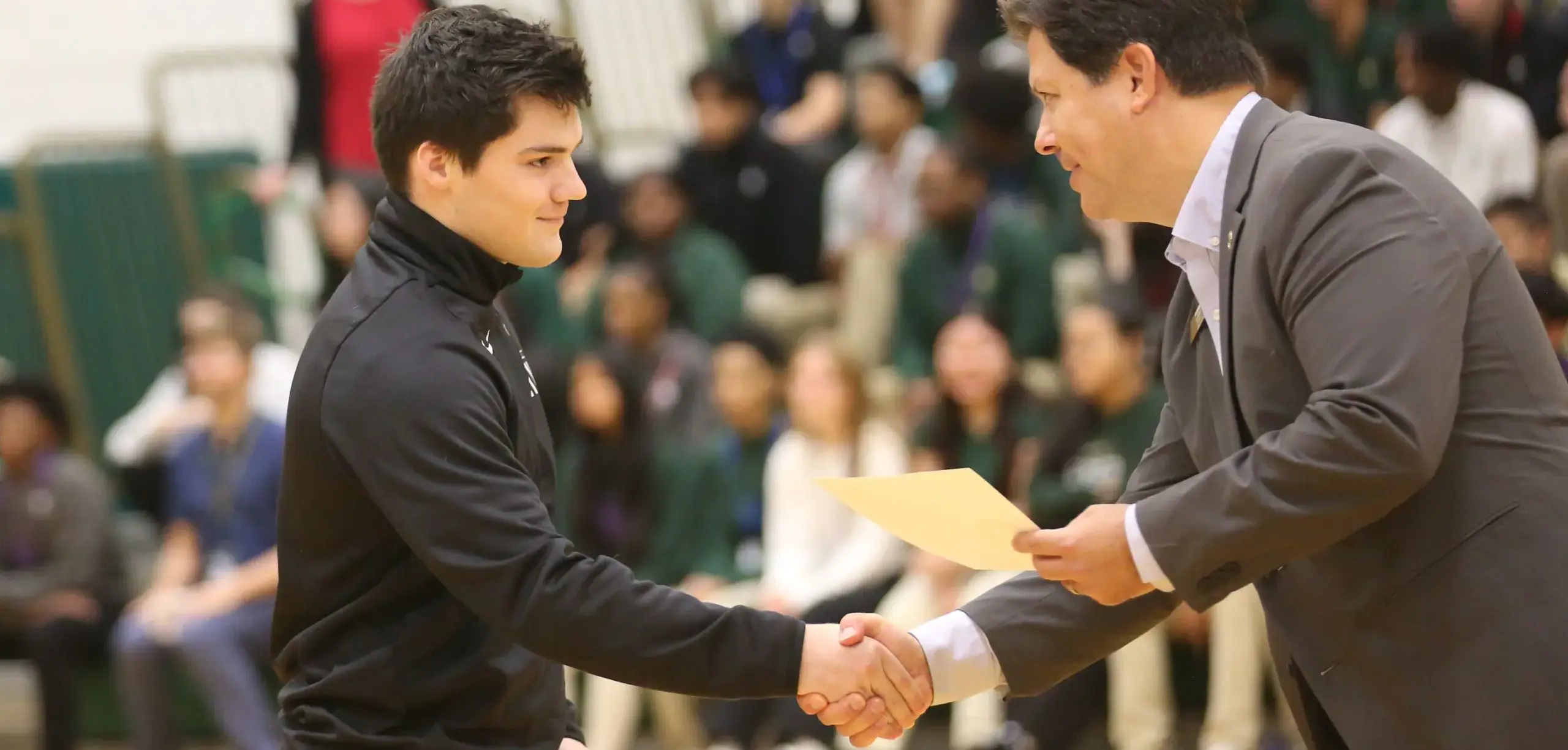 St Vincent St Mary High School student receiving certificate, shaking hands with teacher,