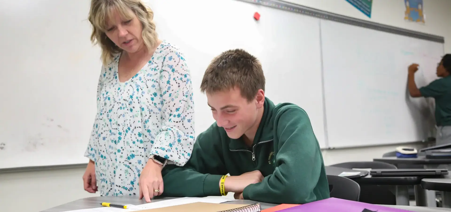 St Vincent St Mary High School teacher assisting a student with classwork.