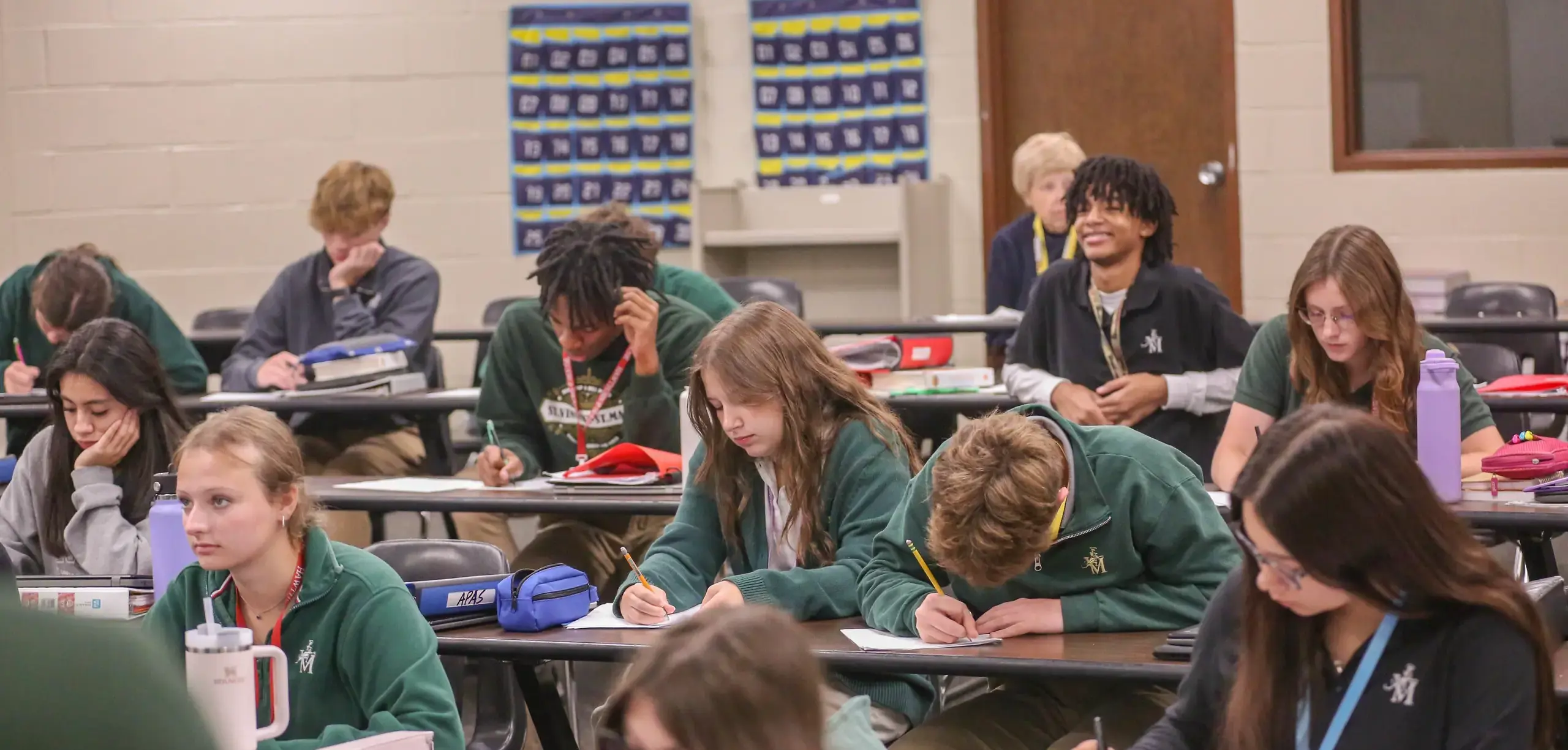 St Vincent St Mary High School students taking notes and listening attentively in a class.