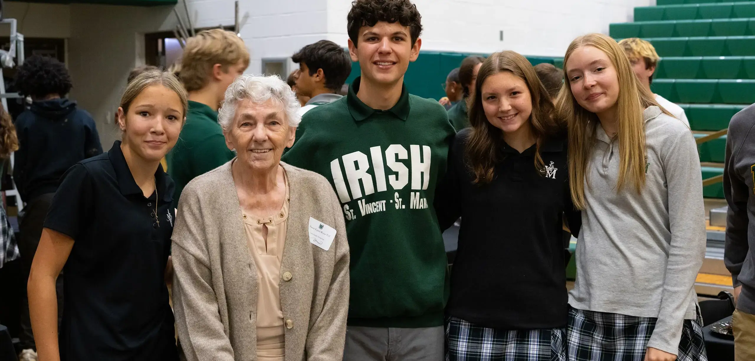 STVM students smile for a photograph with an alumna at am event.