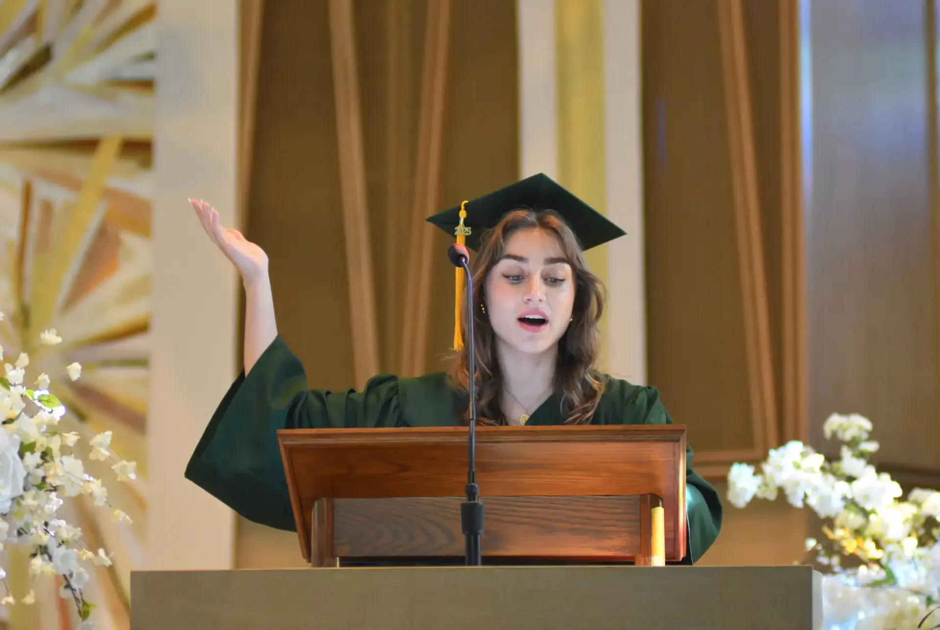 STVM student giving a speech from a lectern at graduation.