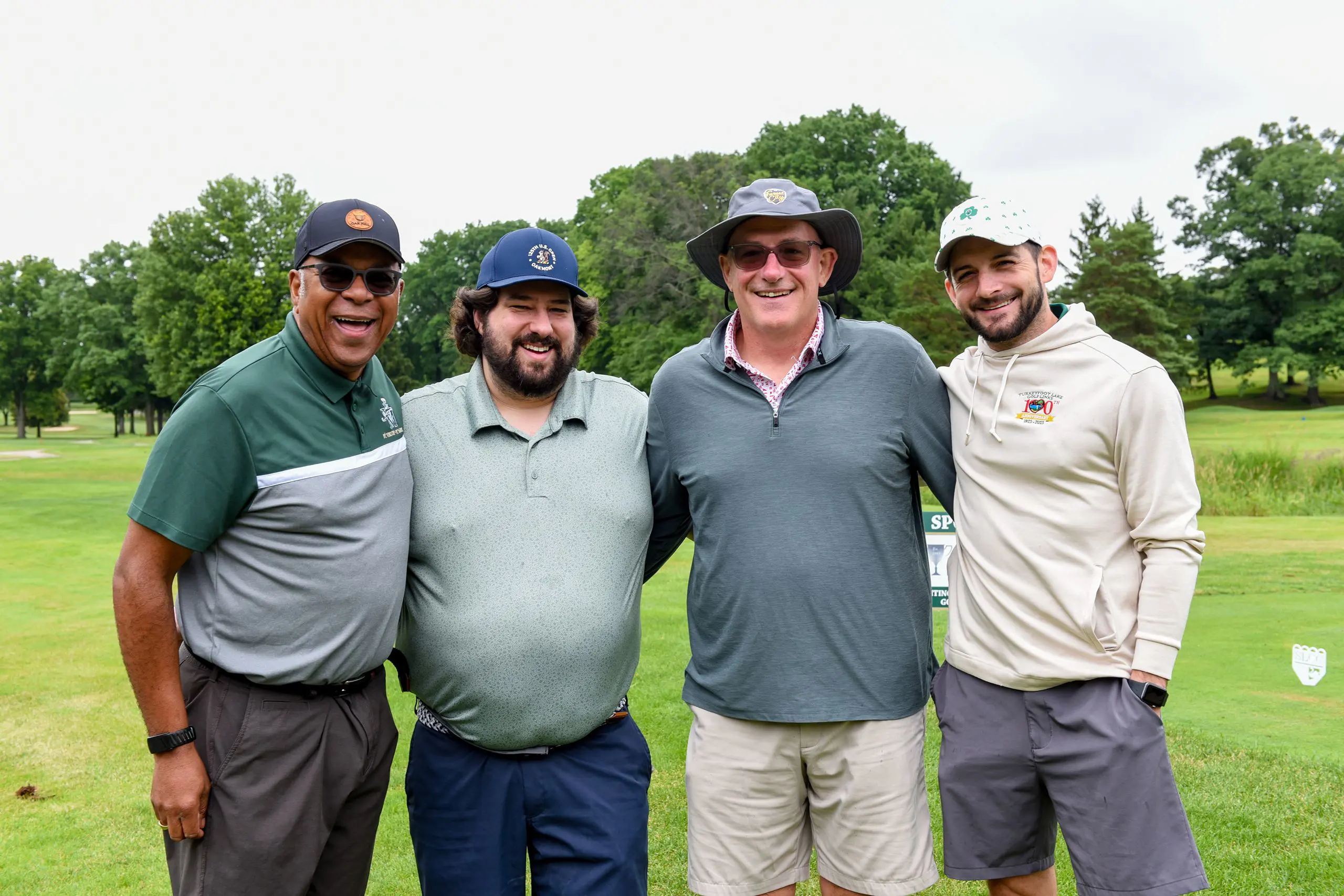 Guests on the golf course taking part in the STVM Golf Outing, smiling happily.