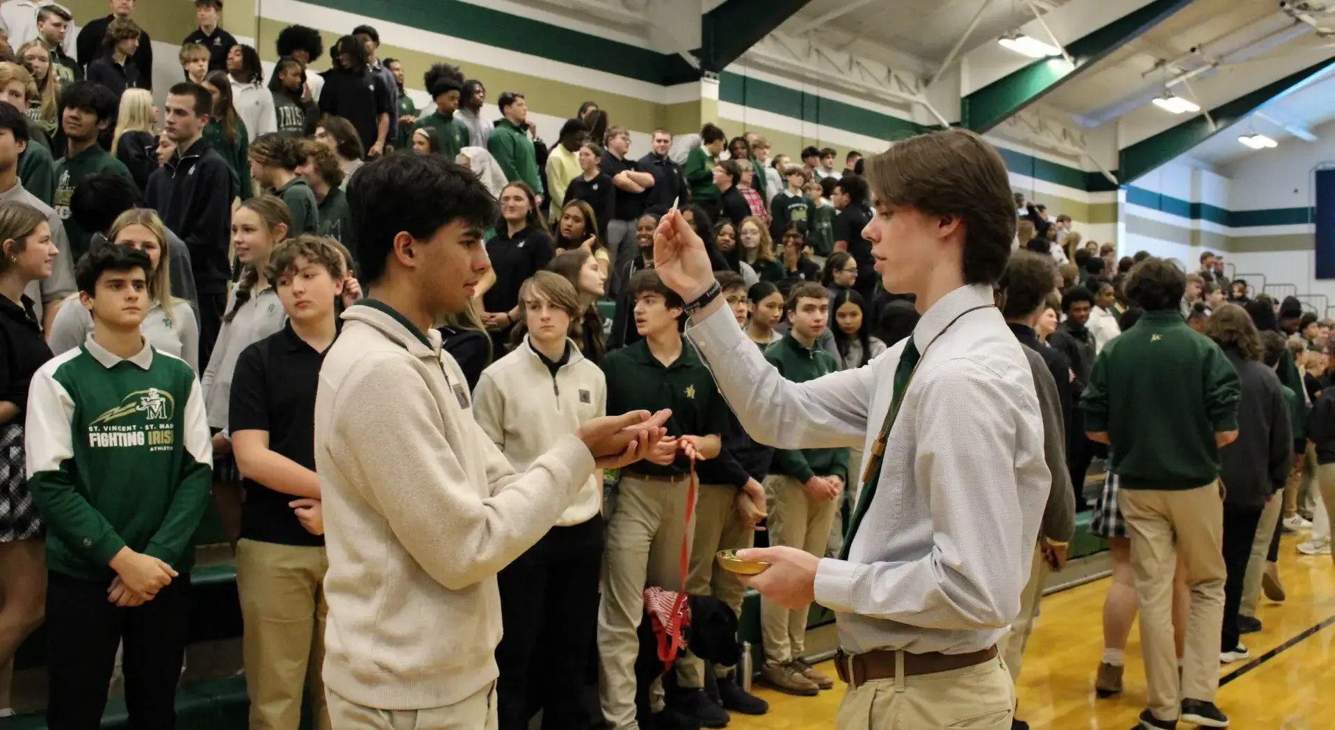 STVM student crowning a statue of St. Mary with a wreath.