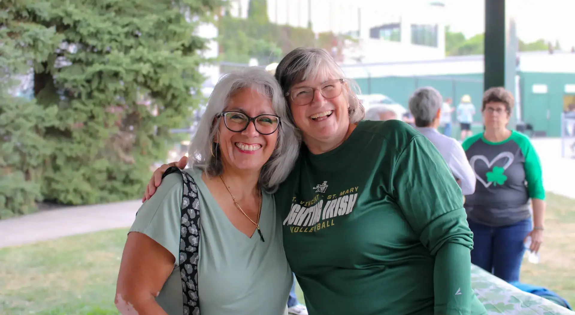 St Vincent St Mary High School alumni smiling for a photograph at an alumni event, smiling and laughing joyfully.