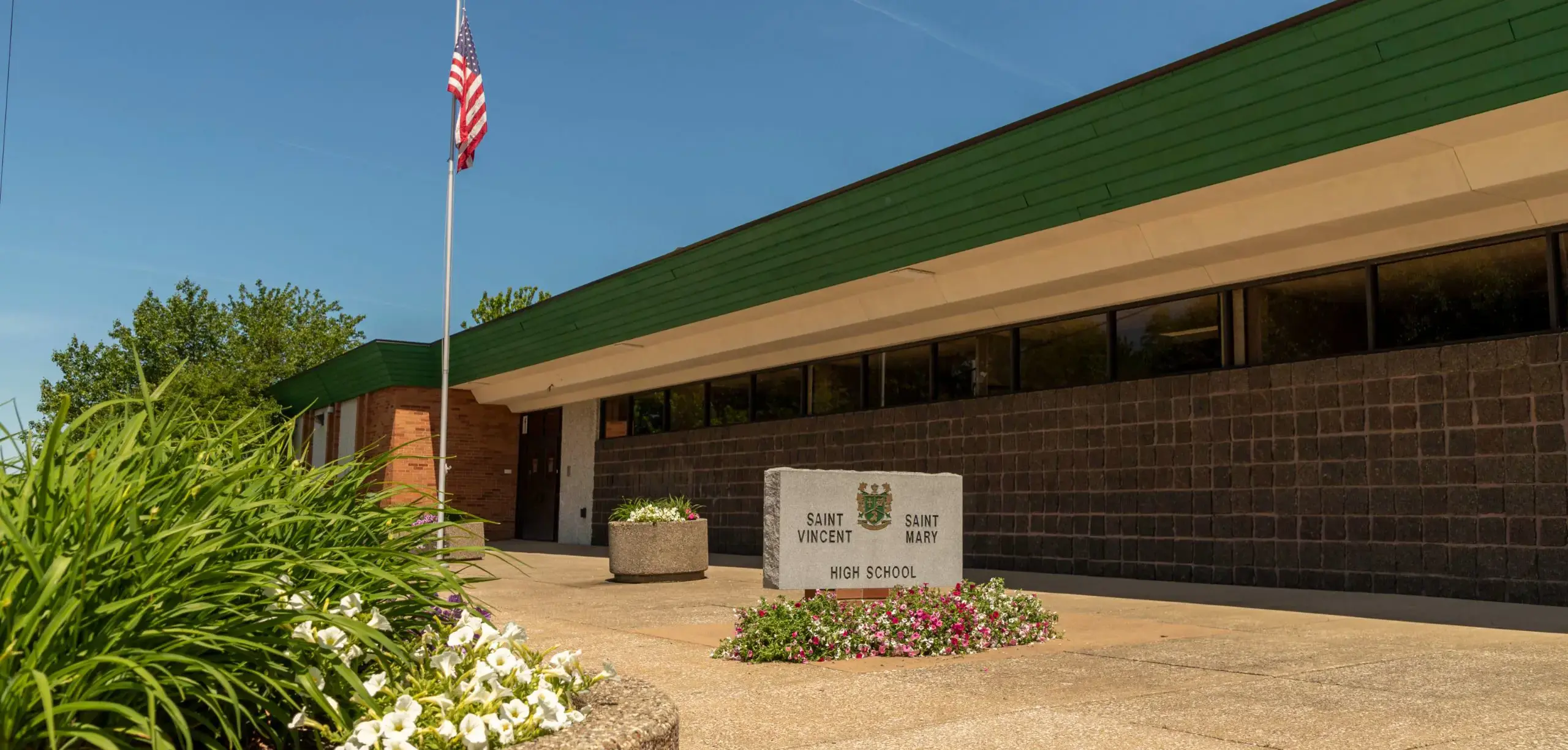 External view of St. Vincent-St. Mary High School school building and USA flag.
