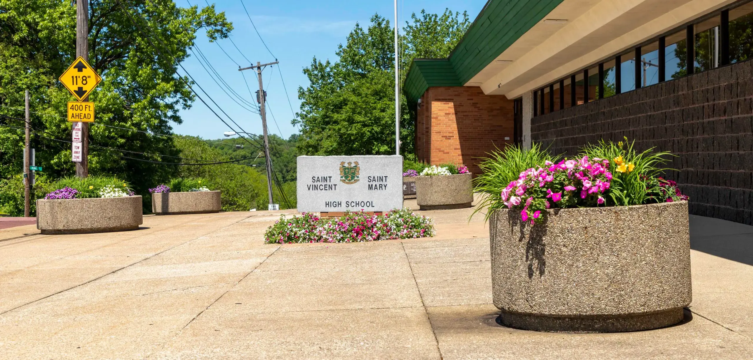 St. Vincent-St. Mary High School exterior with sign and flower planters.