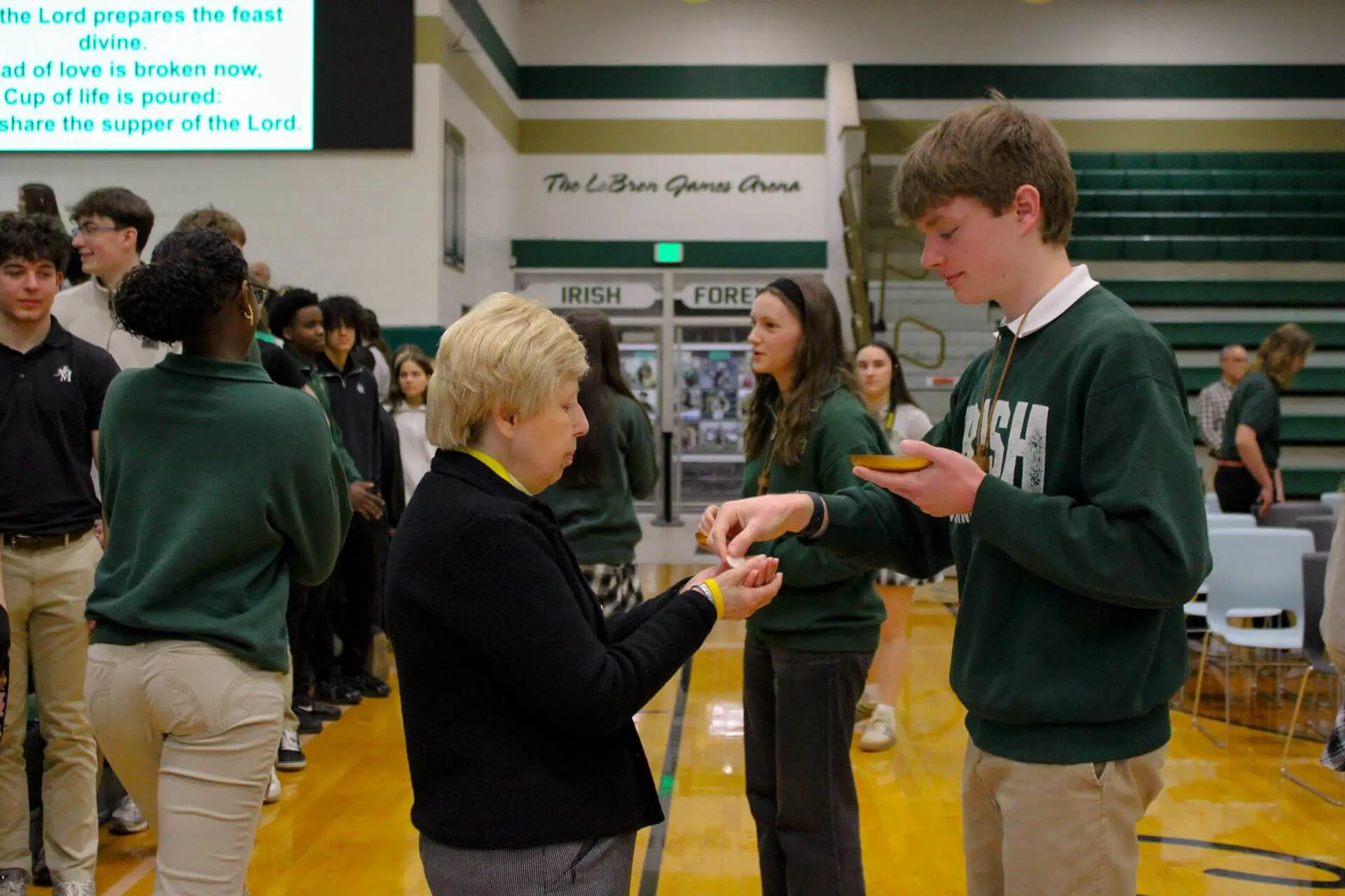 STVM students taking part in the eucharist during a mass in the school gymnasium.