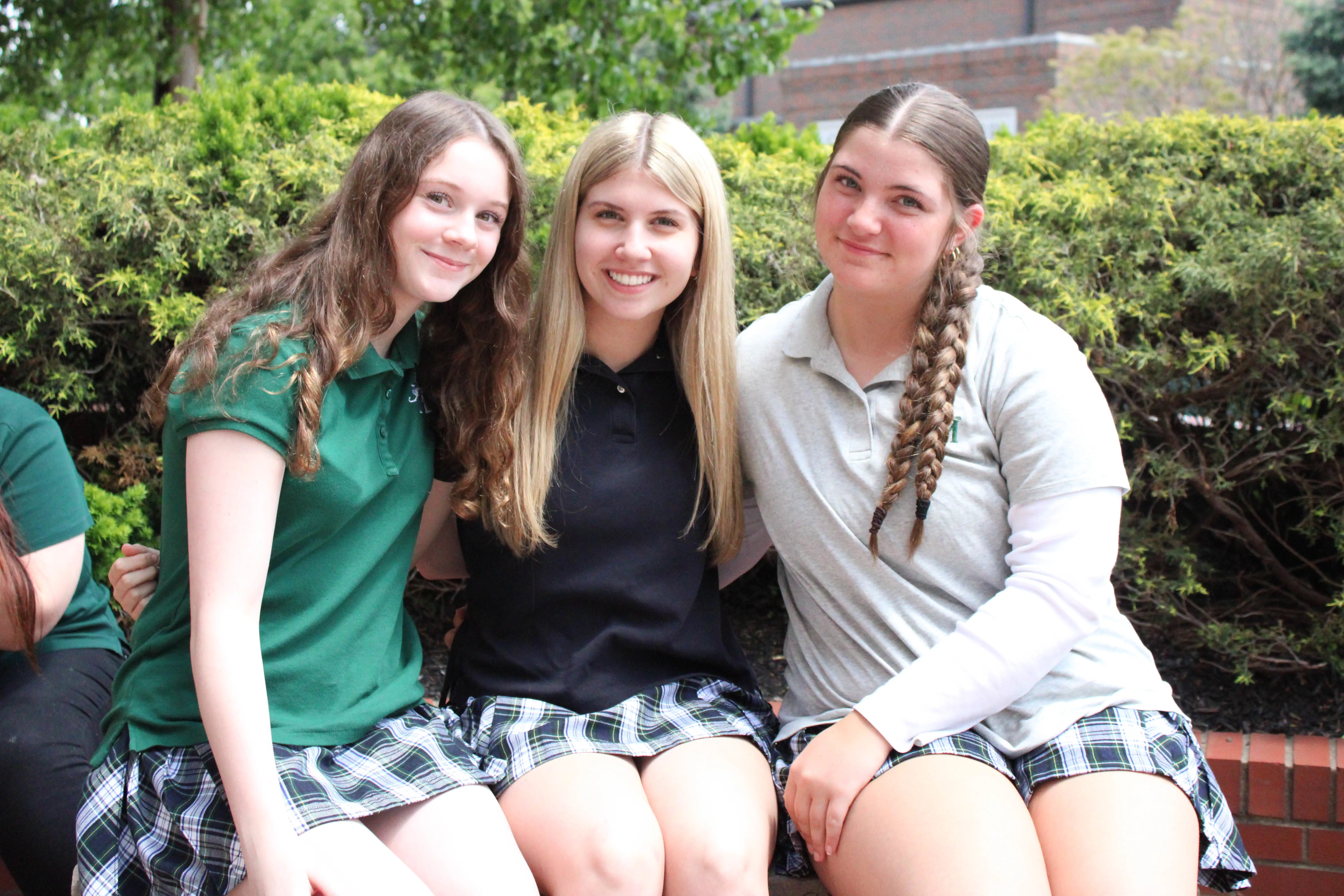 St. Vincent-St. Mary High School students standing by their lockers, smiling, wearing STVM uniforms.