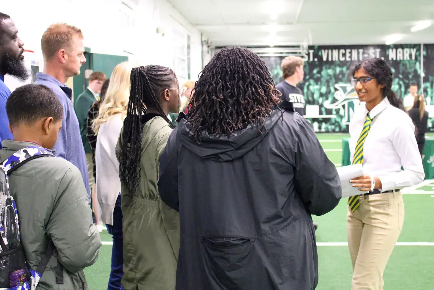 Prospective STVM families visiting the school and talking to a student in unform.