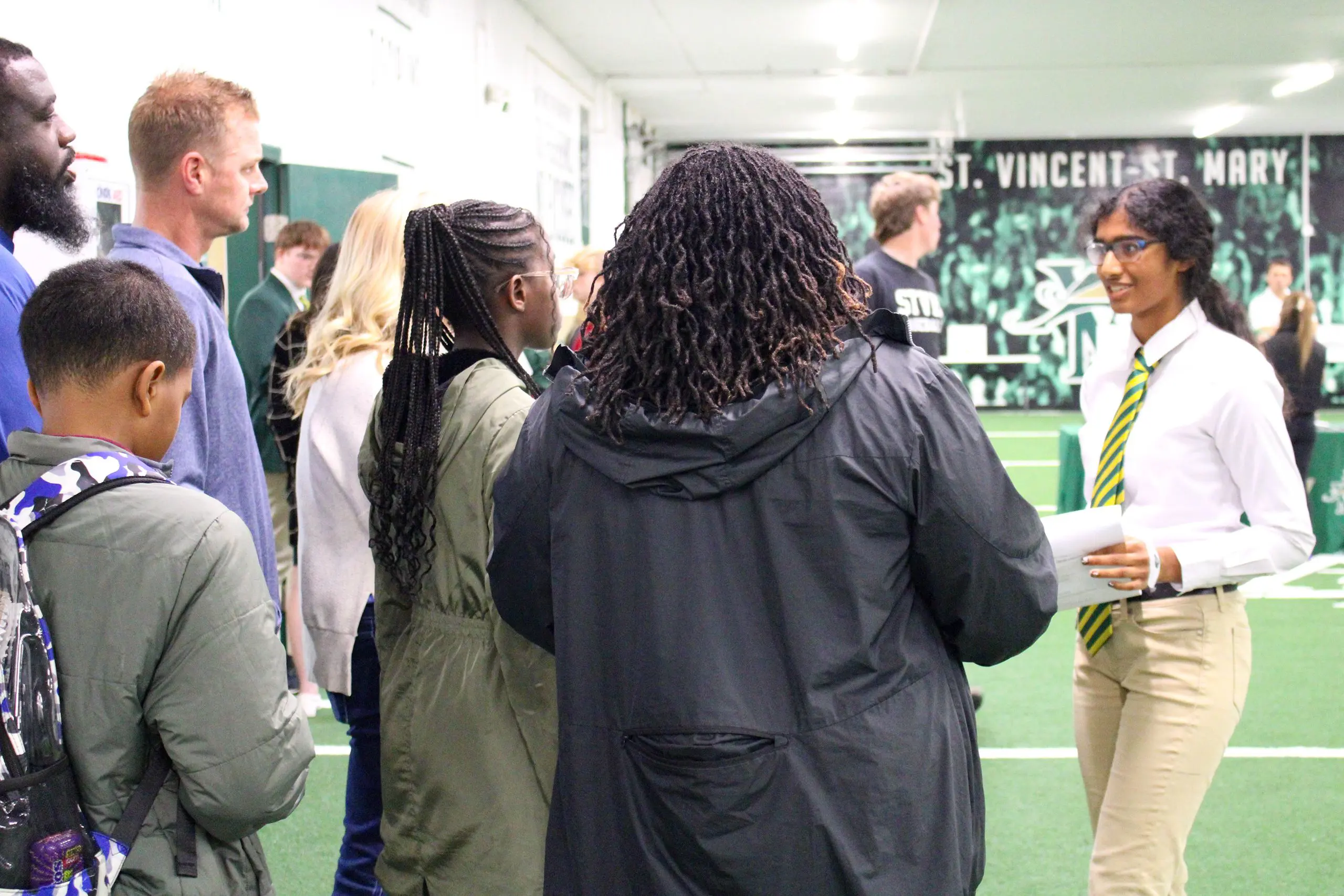Prospective STVM families visiting the school and talking to a student in unform.