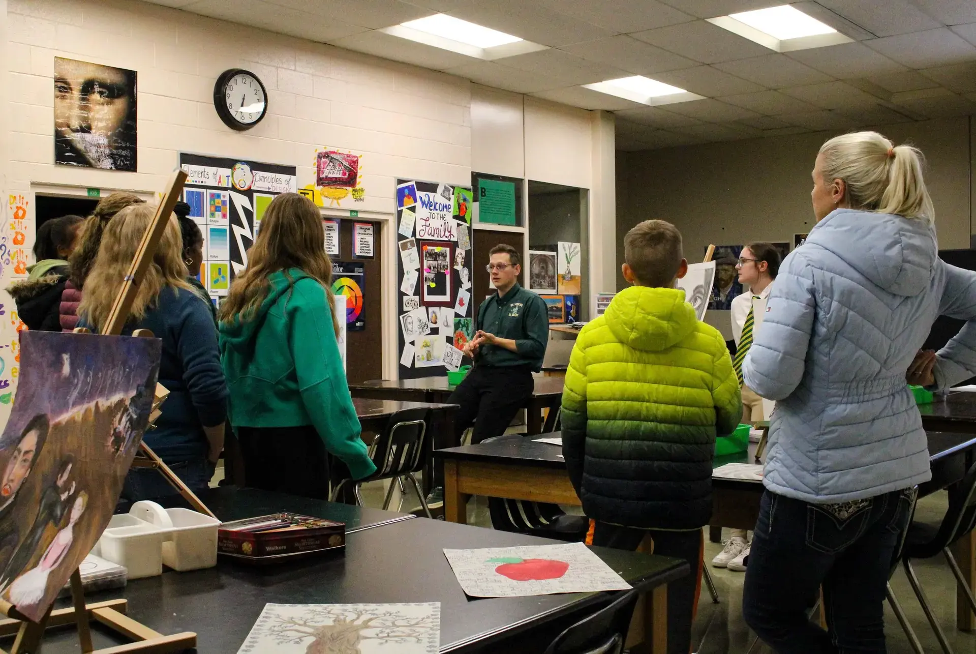STVM teacher talking to parents in an art classroom at an open house event.