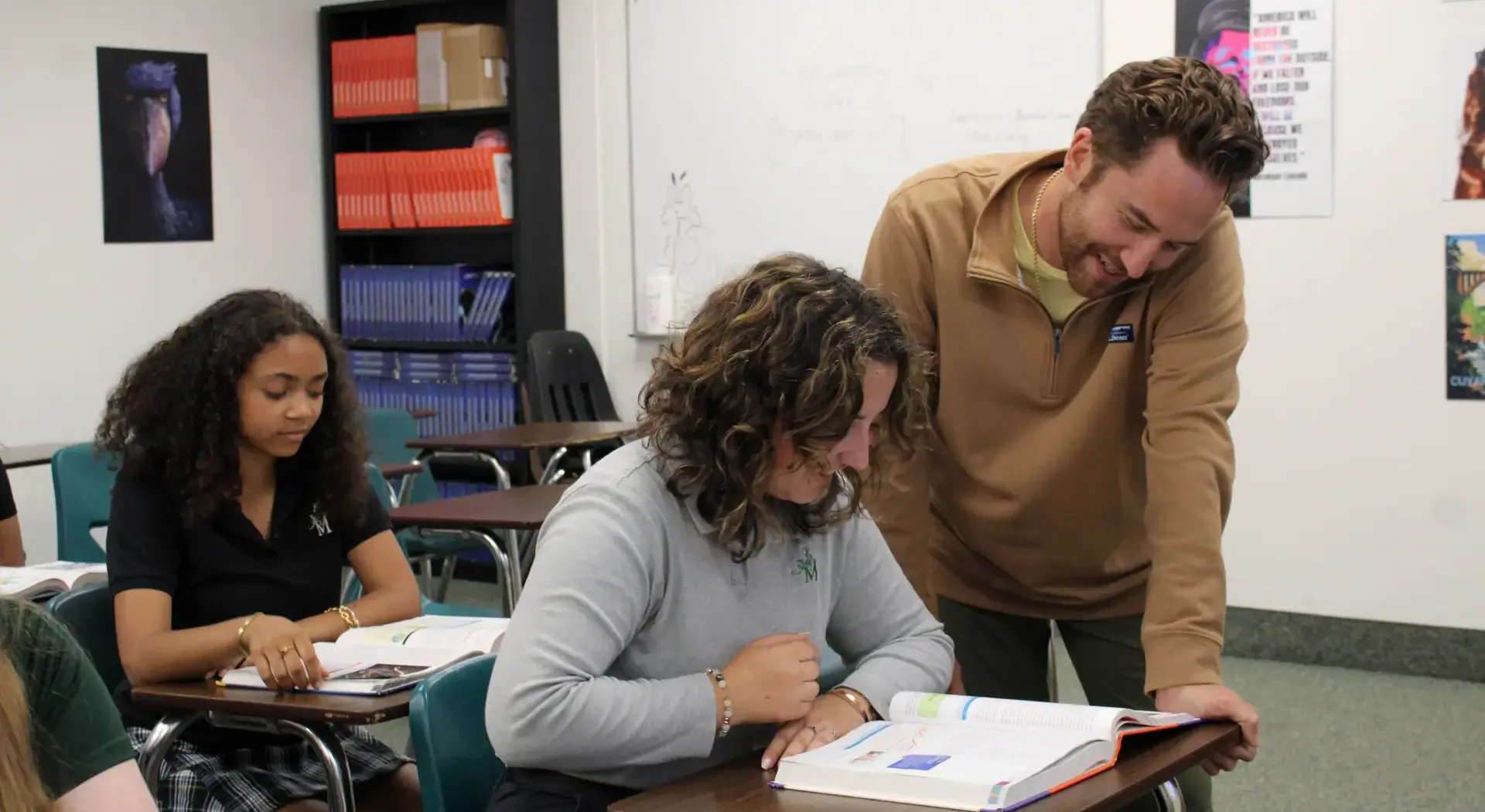 STVM teacher looking at a textbook with a student in class.