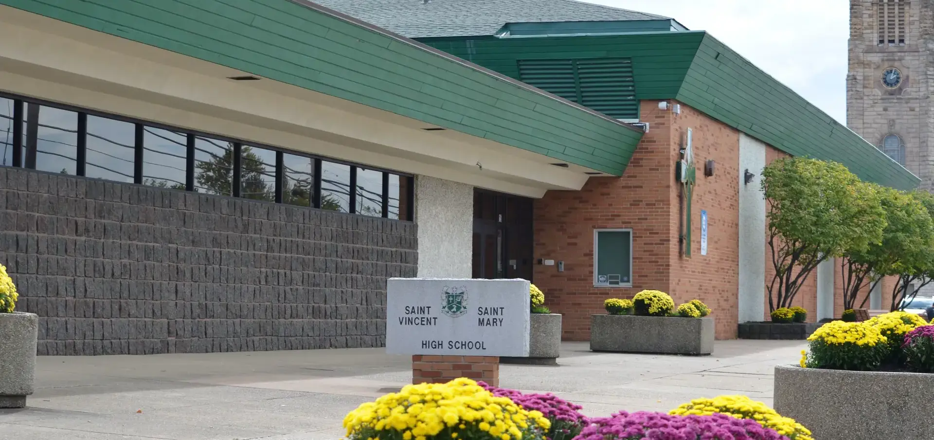 St Vincent St Mary High School external photo with sign and flowers.
