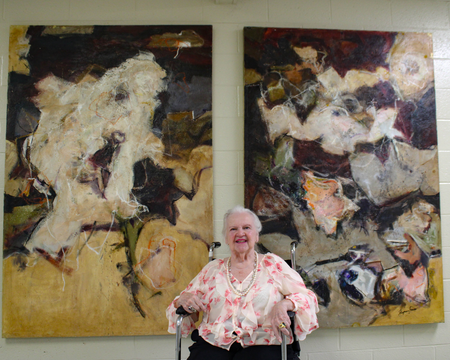 Mary Ann Flynn-Fouse posing with paintings