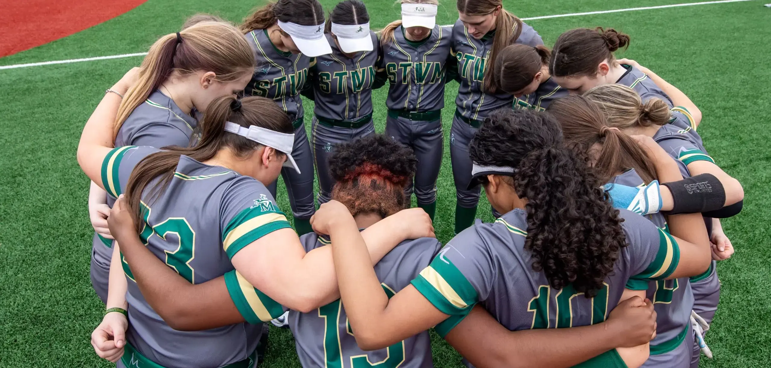St Vincent St Mary High School student softball team huddle.